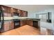 Modern kitchen with wood cabinets, granite countertops, and black appliances at 3310 S Oneida Way, Denver, CO 80224