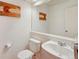 Well-lit half bathroom featuring a modern vanity, a toilet, and a decorative mirror at 2408 Concord Cir, Lafayette, CO 80026