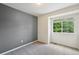 Cozy bedroom with plush carpet, a large window, and a soothing gray accent wall at 2408 Concord Cir, Lafayette, CO 80026