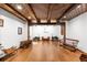 Expansive room with wood floors, beamed ceilings, and display of antique carriages at 689 Red Deer Rd, Franktown, CO 80116