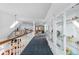 Bright hallway featuring a display cabinet, skylight and railing overlooking the lower level at 689 Red Deer Rd, Franktown, CO 80116