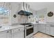 Charming kitchen with white cabinetry, granite countertops, a white range hood, and natural light at 689 Red Deer Rd, Franktown, CO 80116
