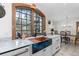 Bright kitchen with a copper sink, white marble countertops, white cabinetry, and a view of the outdoors at 689 Red Deer Rd, Franktown, CO 80116