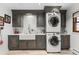 Well-equipped laundry room with cabinetry, farmhouse sink, and stacked washer/dryer at 689 Red Deer Rd, Franktown, CO 80116