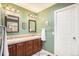 Well-lit bathroom with dual sinks, wood cabinetry, and tile floors at 10247 Telluride Way, Commerce City, CO 80022