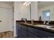 Modern bathroom featuring double sinks, dark cabinetry, granite countertops, and a stylish mirror at 1048 Larkspur Dr, Erie, CO 80516