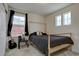 Bright bedroom featuring two windows, wooden bed frame and accent guitar at 1048 Larkspur Dr, Erie, CO 80516