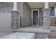 A welcoming front porch featuring stone columns and a wreath on the front door at 1048 Larkspur Dr, Erie, CO 80516