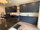 Contemporary kitchen featuring dark cabinets, granite countertops, and modern appliances at 1048 Larkspur Dr, Erie, CO 80516