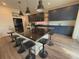 Spacious kitchen featuring a large island with seating, navy cabinets, granite countertops, and modern lighting at 1048 Larkspur Dr, Erie, CO 80516