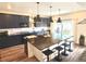 Stylish kitchen boasts granite countertops, dark cabinetry, a center island, and modern pendant lighting at 1048 Larkspur Dr, Erie, CO 80516