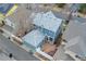 Aerial view of a blue two-story home with a detached garage, private yard, and a nearby neighborhood street at 7860 E Ellsworth Ave, Denver, CO 80230