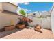 Enclosed backyard featuring a brick patio, raised garden beds, and a white picket fence for privacy at 7860 E Ellsworth Ave, Denver, CO 80230