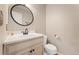 Elegant half-bath features a decorative mirror, a toilet, and under sink storage at 7860 E Ellsworth Ave, Denver, CO 80230