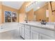 Elegant primary bathroom with marble countertops, tub, and large mirror at 7860 E Ellsworth Ave, Denver, CO 80230