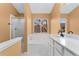 Bright bathroom featuring a walk-in shower, soaking tub, and updated vanity with marble countertop at 7860 E Ellsworth Ave, Denver, CO 80230