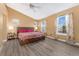 Bedroom features two bright windows, wood-look floors, and a wooden bed frame at 7860 E Ellsworth Ave, Denver, CO 80230