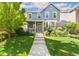 Charming blue two-story home featuring a inviting front porch and well-manicured landscaping at 7860 E Ellsworth Ave, Denver, CO 80230