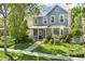Charming home exterior with a inviting front porch, well-kept lawn, and mature trees at 7860 E Ellsworth Ave, Denver, CO 80230