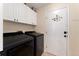 Convenient laundry room with modern washer and dryer and white storage cabinets at 7860 E Ellsworth Ave, Denver, CO 80230