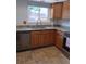 Updated kitchen featuring wood cabinets, granite countertops, and stainless steel dishwasher at 12640 W Virginia Ave, Lakewood, CO 80228