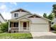 Two-story house with a beige exterior, attached garage, and front porch at 470 Grey Swallow St, Brighton, CO 80601