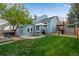 Expansive backyard with a hot tub, outdoor dining area, play structure, and a lush lawn for recreation at 11551 W 103Rd Dr, Broomfield, CO 80021