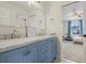 Bathroom with double sinks, blue cabinets, and tile floors; bedroom visible through door at 854 Countrybriar Ln, Highlands Ranch, CO 80129