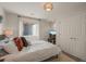 Bedroom with a white bedspread, egress window, and closet with double doors at 854 Countrybriar Ln, Highlands Ranch, CO 80129