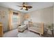 This Bedroom has a crib, glider, ottoman and ceiling fan with natural wood blades at 854 Countrybriar Ln, Highlands Ranch, CO 80129