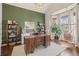 Well-lit home office with desk, shelving, large windows, and comfortable decor at 854 Countrybriar Ln, Highlands Ranch, CO 80129