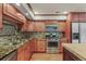 Kitchen with wooden cabinets, stainless steel appliances, granite counters and hardwood floors at 854 Countrybriar Ln, Highlands Ranch, CO 80129