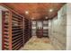 A cozy wine cellar with wooden shelves for bottle storage, a barrel table, and tiled floors at 854 Countrybriar Ln, Highlands Ranch, CO 80129