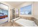 Bright bathroom featuring a glass shower, tub, and view into bedroom at 2730 River View Dr, Broomfield, CO 80023