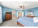 Well-lit bedroom with blue walls, carpet flooring, and a connecting door to an ensuite bathroom at 2730 River View Dr, Broomfield, CO 80023