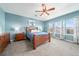 Comfortable bedroom with blue walls, a ceiling fan, and natural light from multiple windows at 2730 River View Dr, Broomfield, CO 80023
