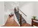 Inviting entryway featuring hardwood floors and a staircase with dark wood banister and decorative iron spindles at 2730 River View Dr, Broomfield, CO 80023