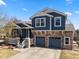 Charming two-story home with a stone and siding exterior, a covered porch, and a two-car garage at 2730 River View Dr, Broomfield, CO 80023