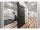 Home gym featuring a sliding barn door and fitness equipment on wood floors at 2730 River View Dr, Broomfield, CO 80023
