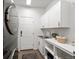 Clean laundry room with white cabinets, a sink, and a modern washer and dryer at 2730 River View Dr, Broomfield, CO 80023