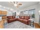 Inviting living room showcasing a leather sectional sofa, ceiling fan and large windows at 2730 River View Dr, Broomfield, CO 80023