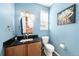 Charming powder room featuring blue walls, a vanity, and a decorative mirror at 2730 River View Dr, Broomfield, CO 80023