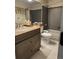 Bathroom with dark cabinetry, decorative elements, and a tiled shower-tub combo at 6833 S Miller St, Littleton, CO 80127