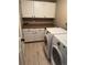 Bright laundry room featuring white cabinets, laminate countertops, and modern washer and dryer at 6833 S Miller St, Littleton, CO 80127