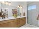 Modern bathroom with double sink vanity, stylish lighting, and a glass-enclosed shower with herringbone tile at 2855 S Pancratia St, Denver, CO 80236