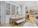 Bright dining area with a wooden table, stylish bench, large windows, and seamless flow into the modern kitchen at 2855 S Pancratia St, Denver, CO 80236