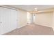 A finished basement room with a large closet, neutral walls, carpet floors, and access to a bathroom at 3608 W Radcliff Ave, Denver, CO 80236