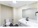 Modern half-bathroom with a vanity, toilet, and mirror at 3608 W Radcliff Ave, Denver, CO 80236