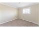 Bedroom featuring neutral walls and carpet, a shuttered window, and base trim at 3608 W Radcliff Ave, Denver, CO 80236