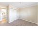 Bedroom showcasing plush carpeting, a closet, neutral walls, and an open bathroom door at 3608 W Radcliff Ave, Denver, CO 80236